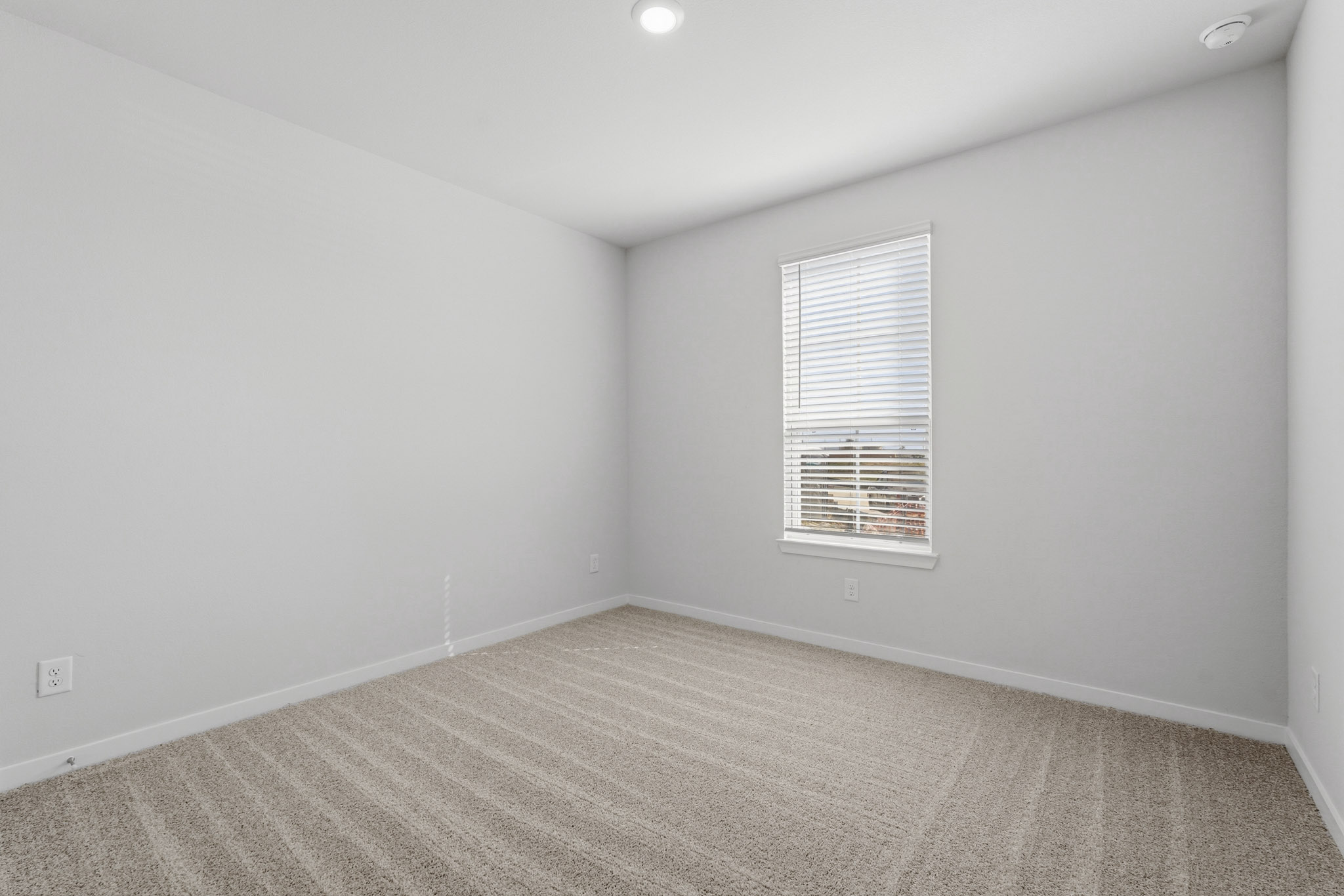 A room with a window and a carpet.