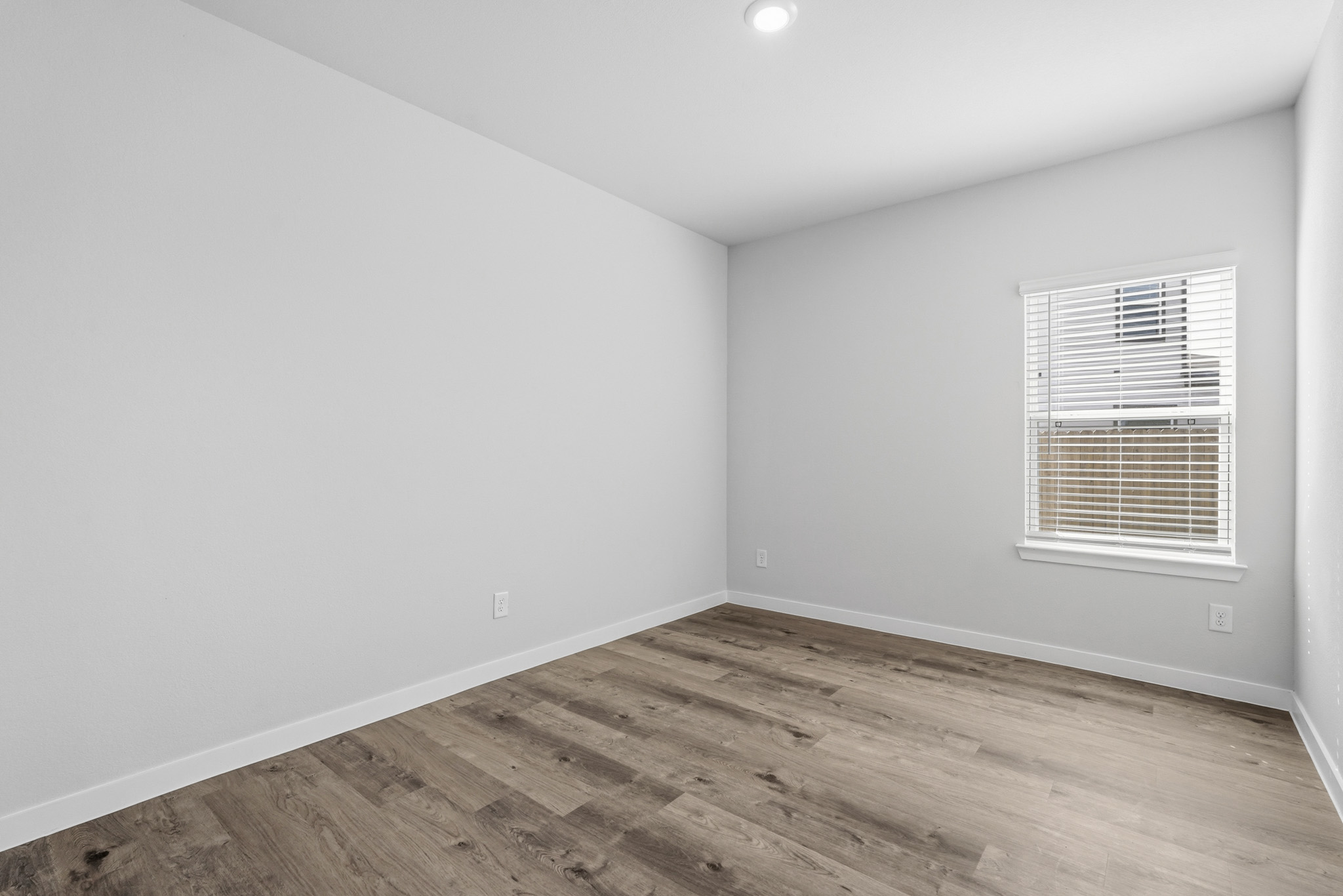 A room with a wood floor and a window.