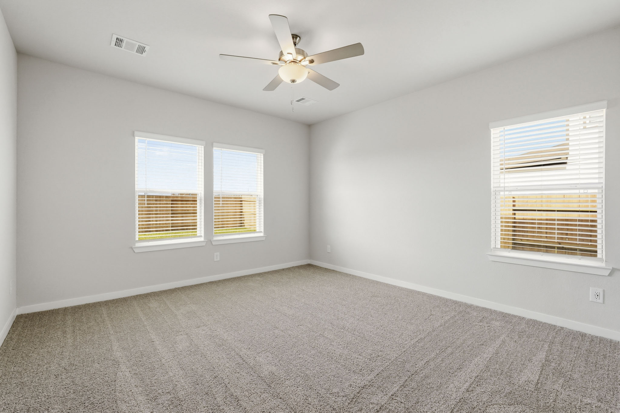 A room with a ceiling fan and a window.