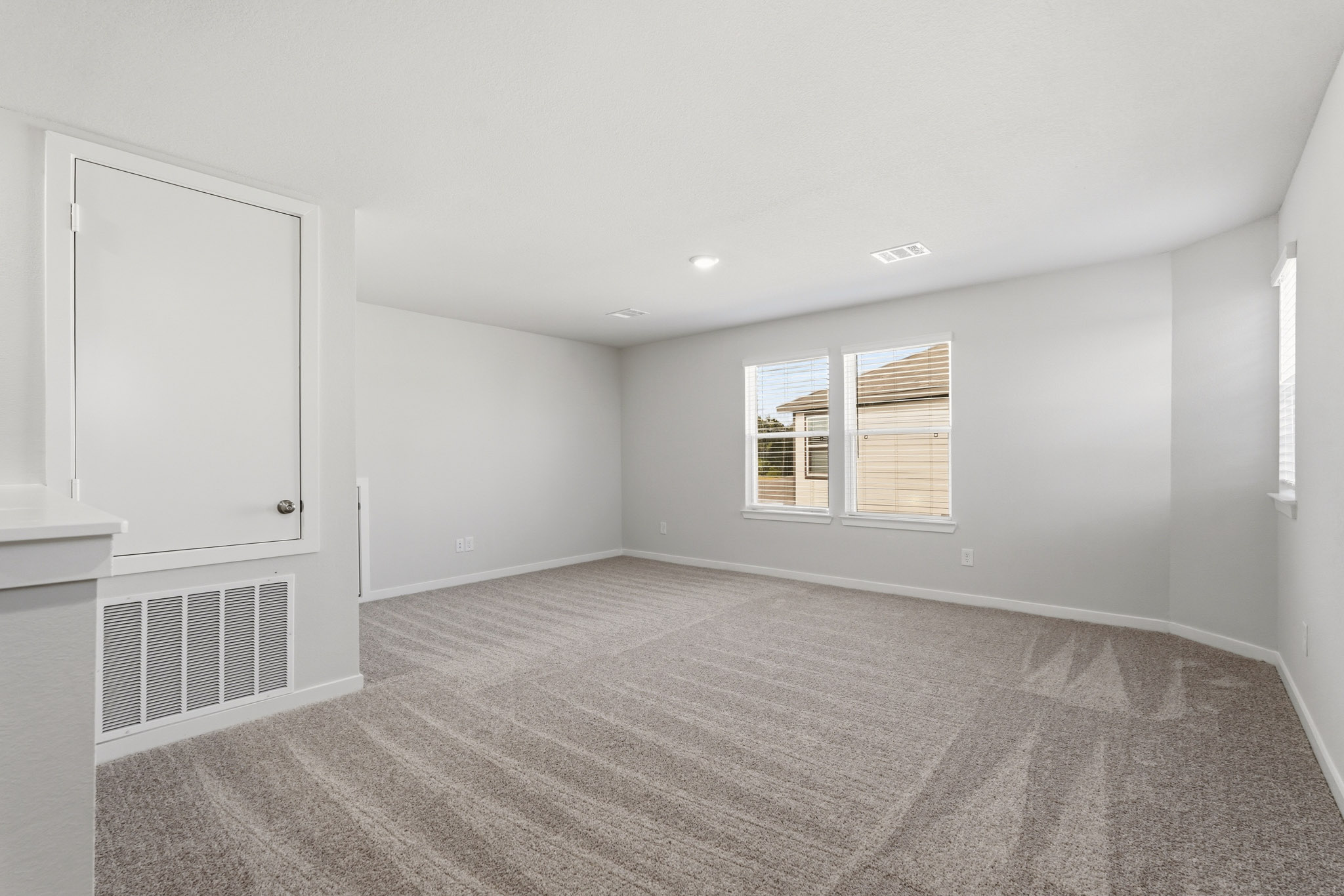 A room with a window and a rug.