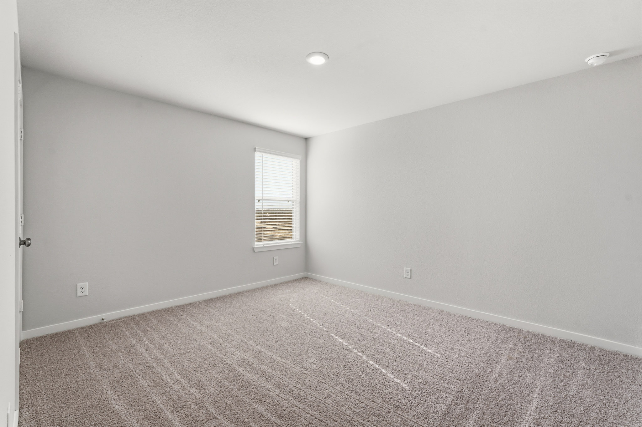 A room with a carpet and a window.