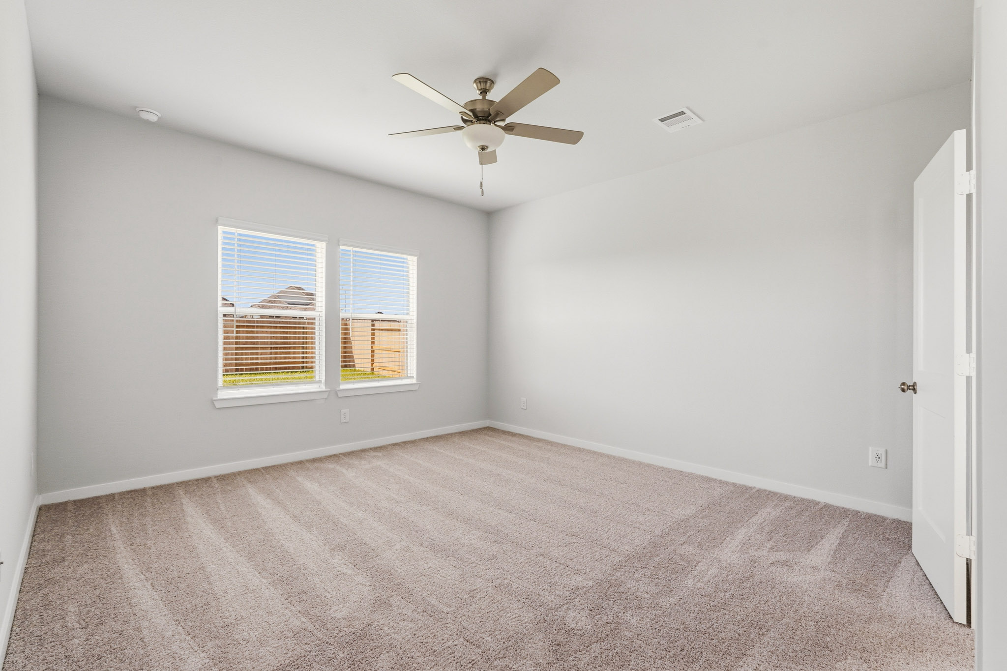 A room with a ceiling fan and a window.