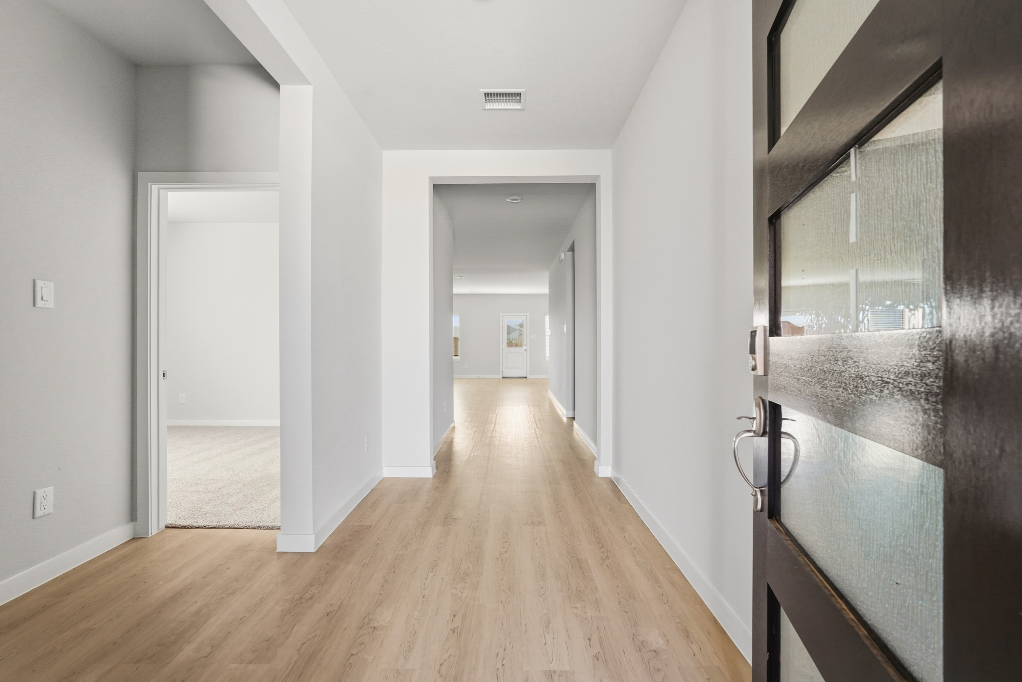 A hallway with a wood floor.