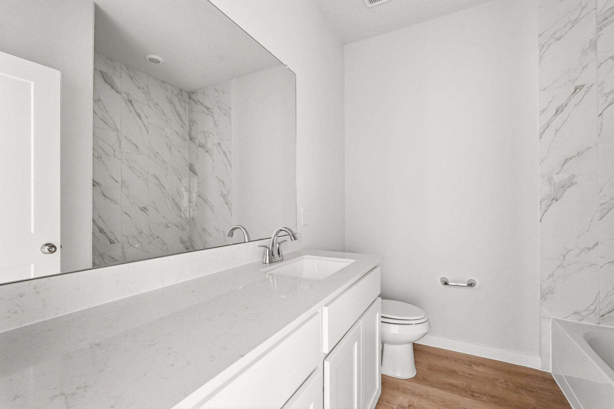 A bathroom with a tub sink and toilet.