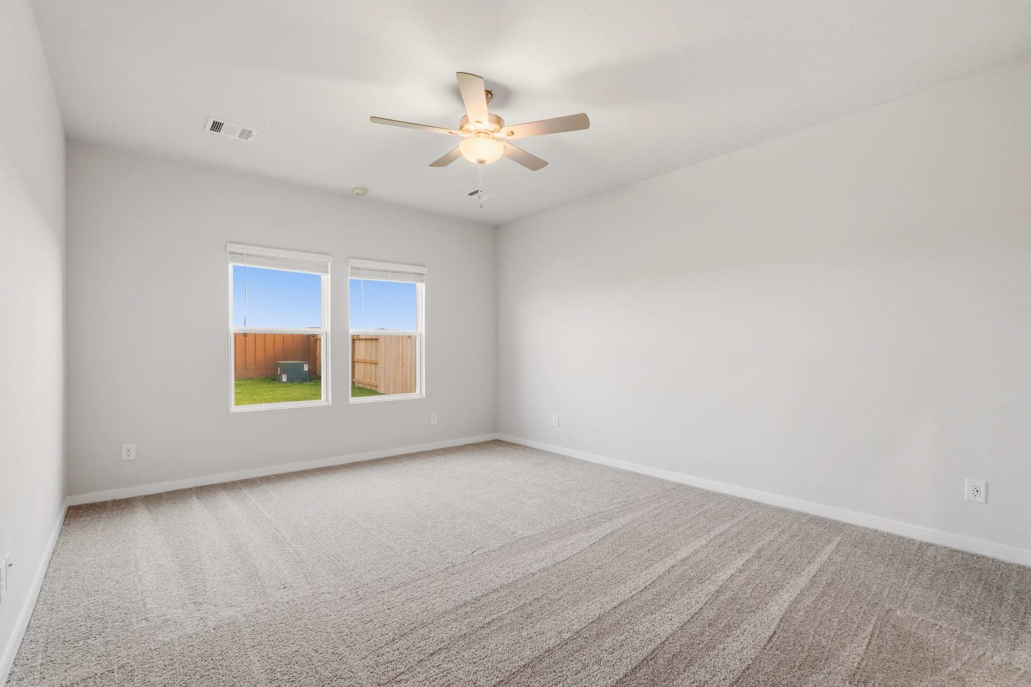 A room with a ceiling fan and a window.