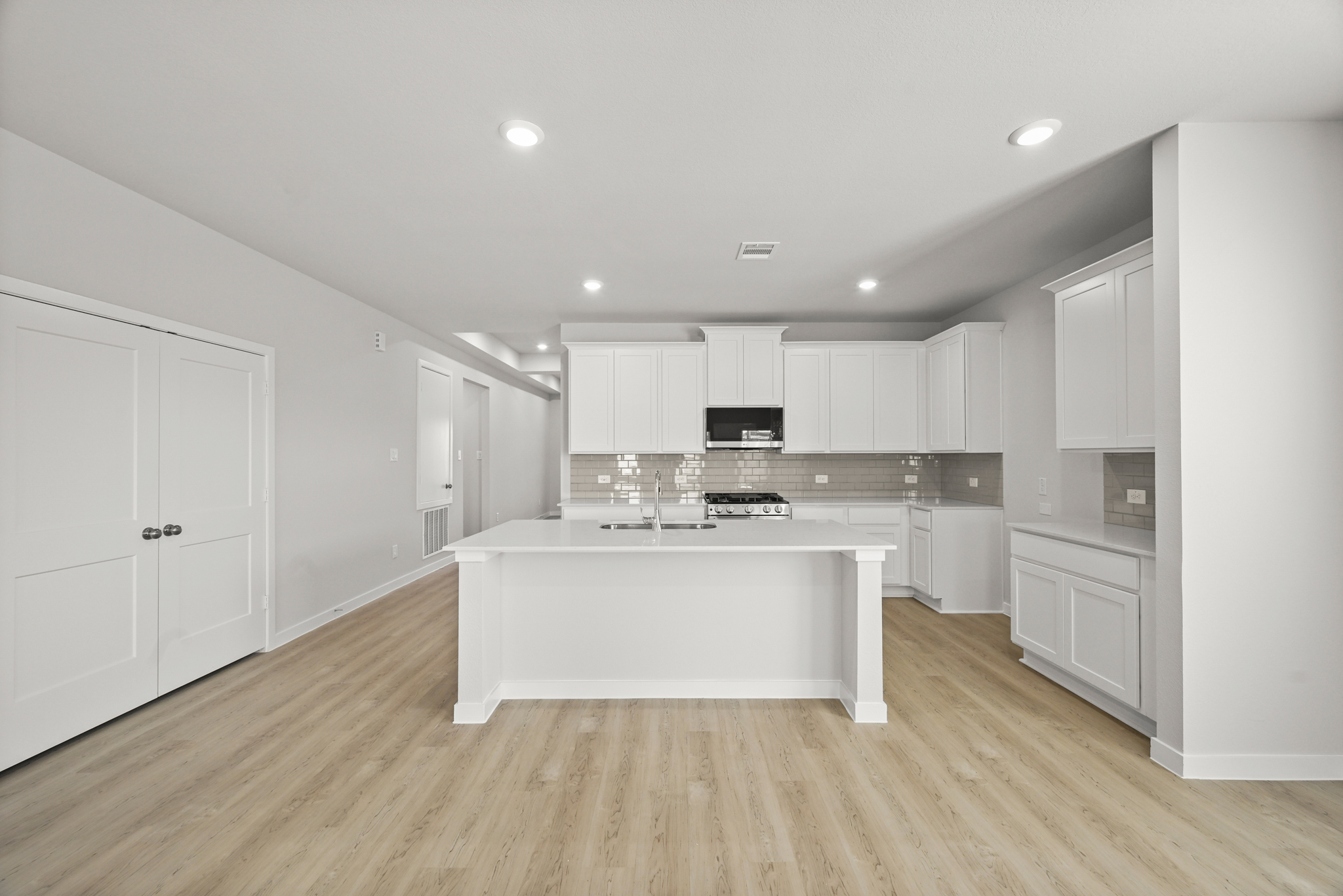 A kitchen with white cabinets.