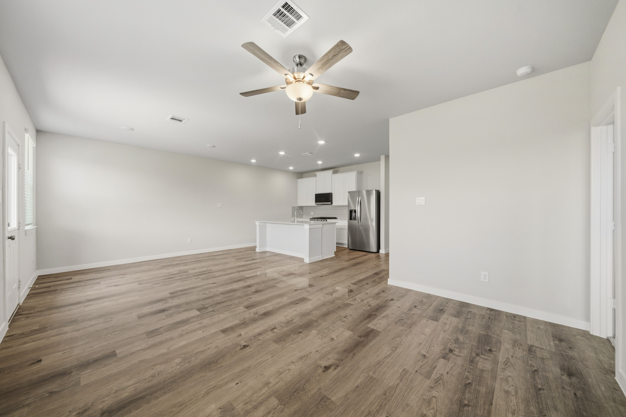 A large kitchen with a wood floor.
