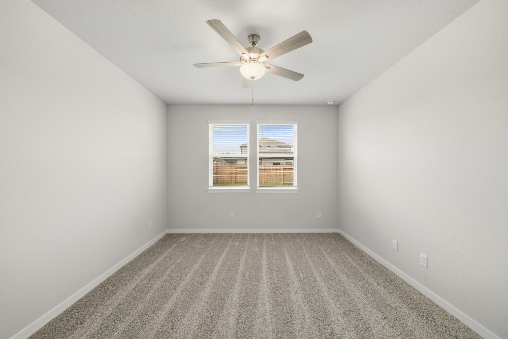 A room with a ceiling fan and a window.