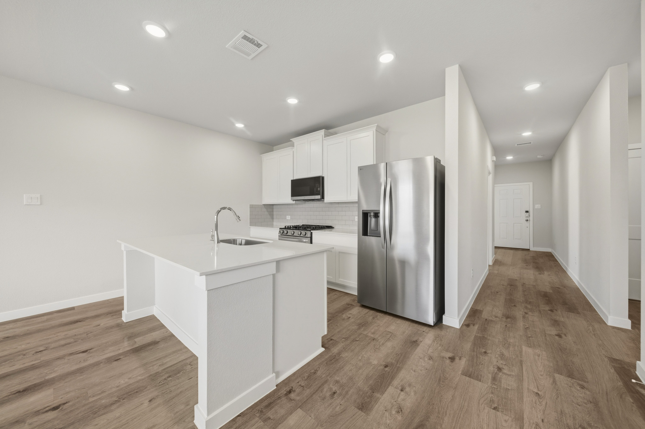 A kitchen with white cabinets.