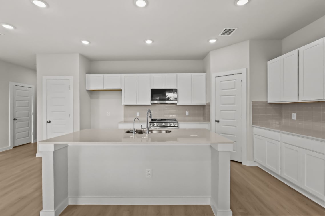 A kitchen with white cabinets.