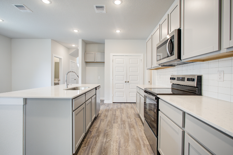 A kitchen with white cabinets.