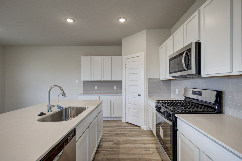 A kitchen with white cabinets.