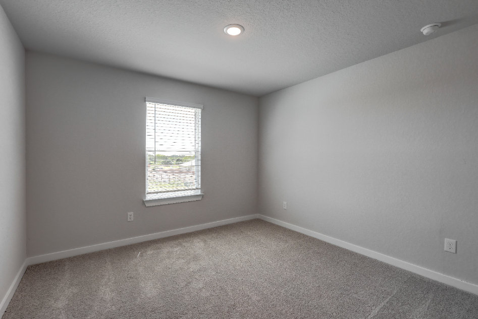 A room with a window and a carpet.