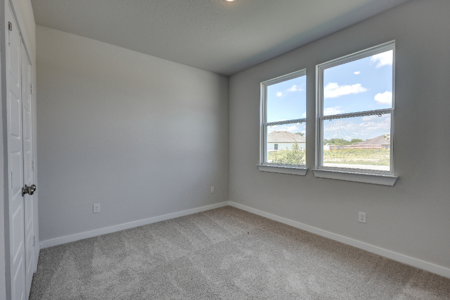 A room with a window and a carpet.