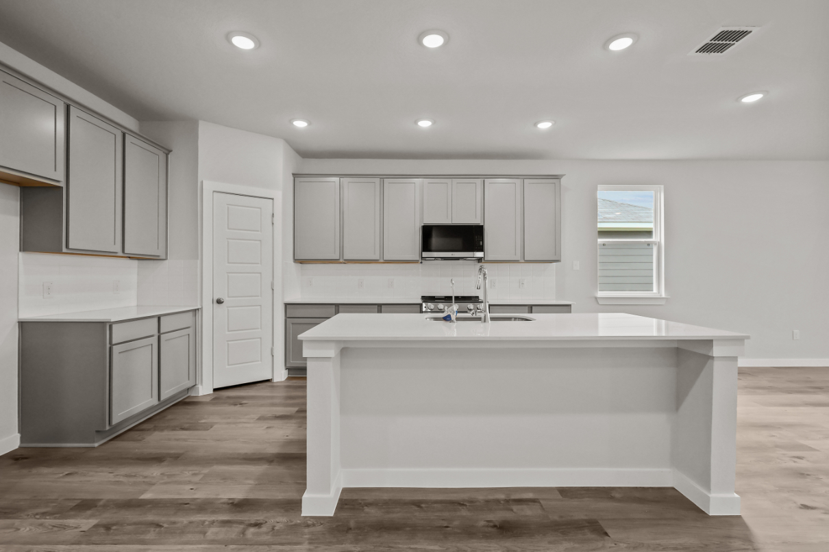 A kitchen with white cabinets.
