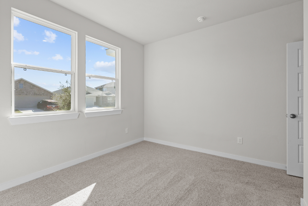 A room with a window and a carpet.