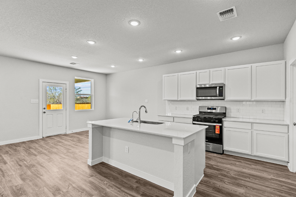 A kitchen with white cabinets.