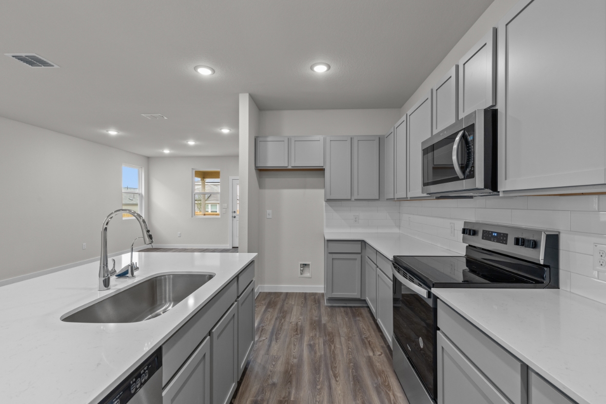 A kitchen with white cabinets.
