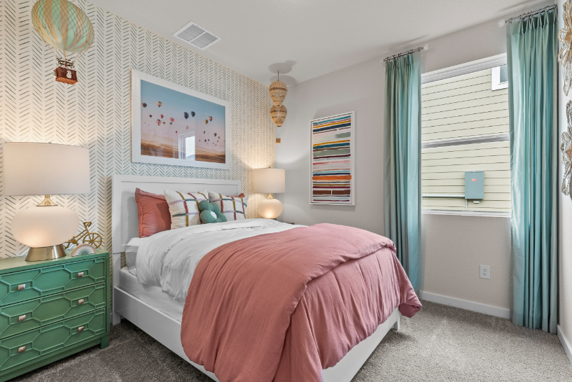 A bedroom with a bed and a lamp.