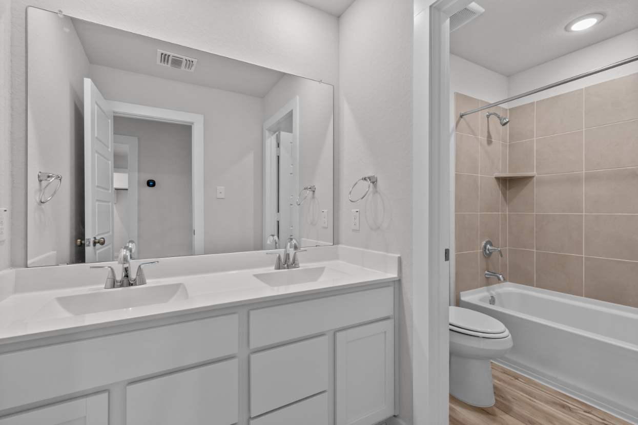 A bathroom with a tub sink and toilet.