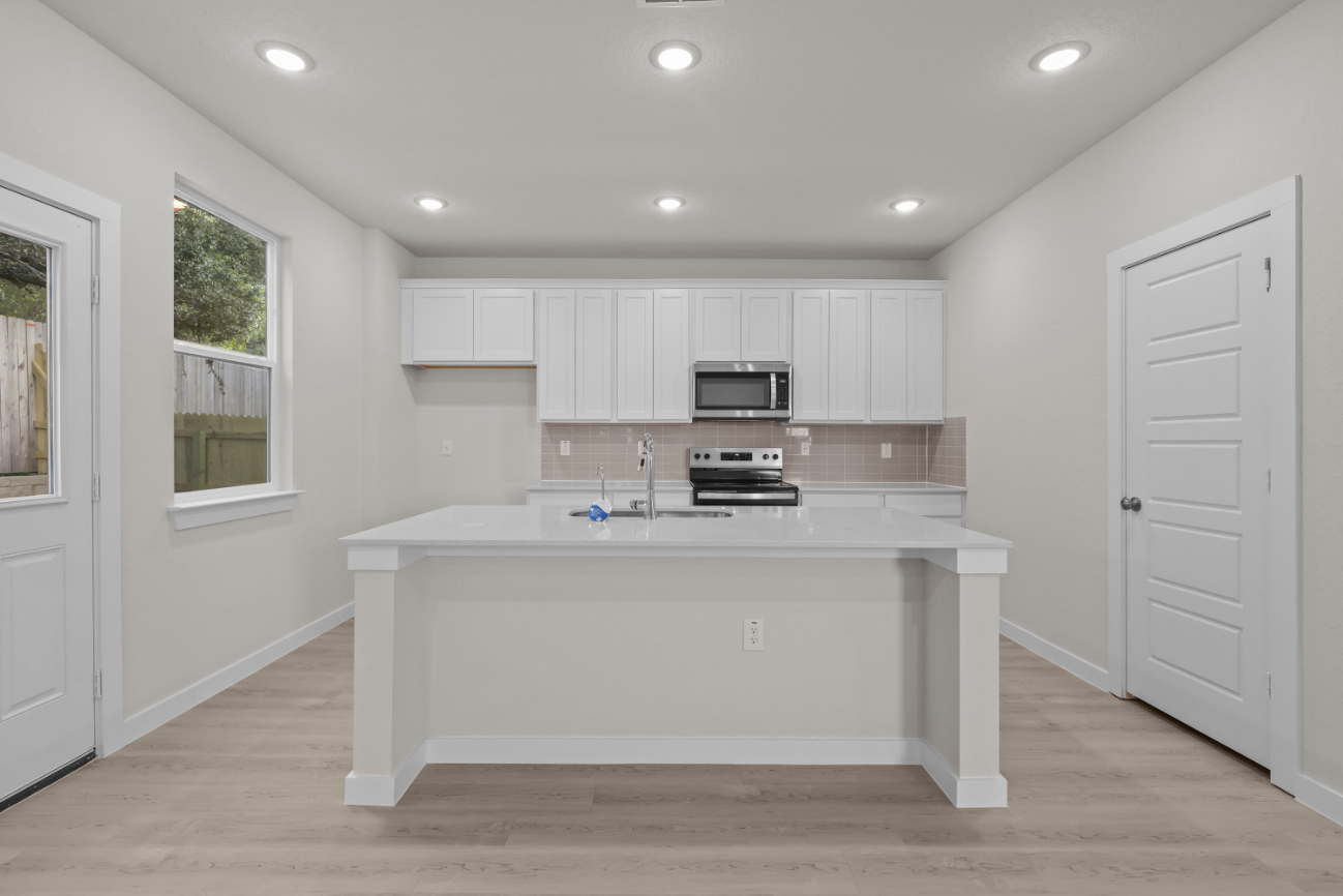 A kitchen with white cabinets.