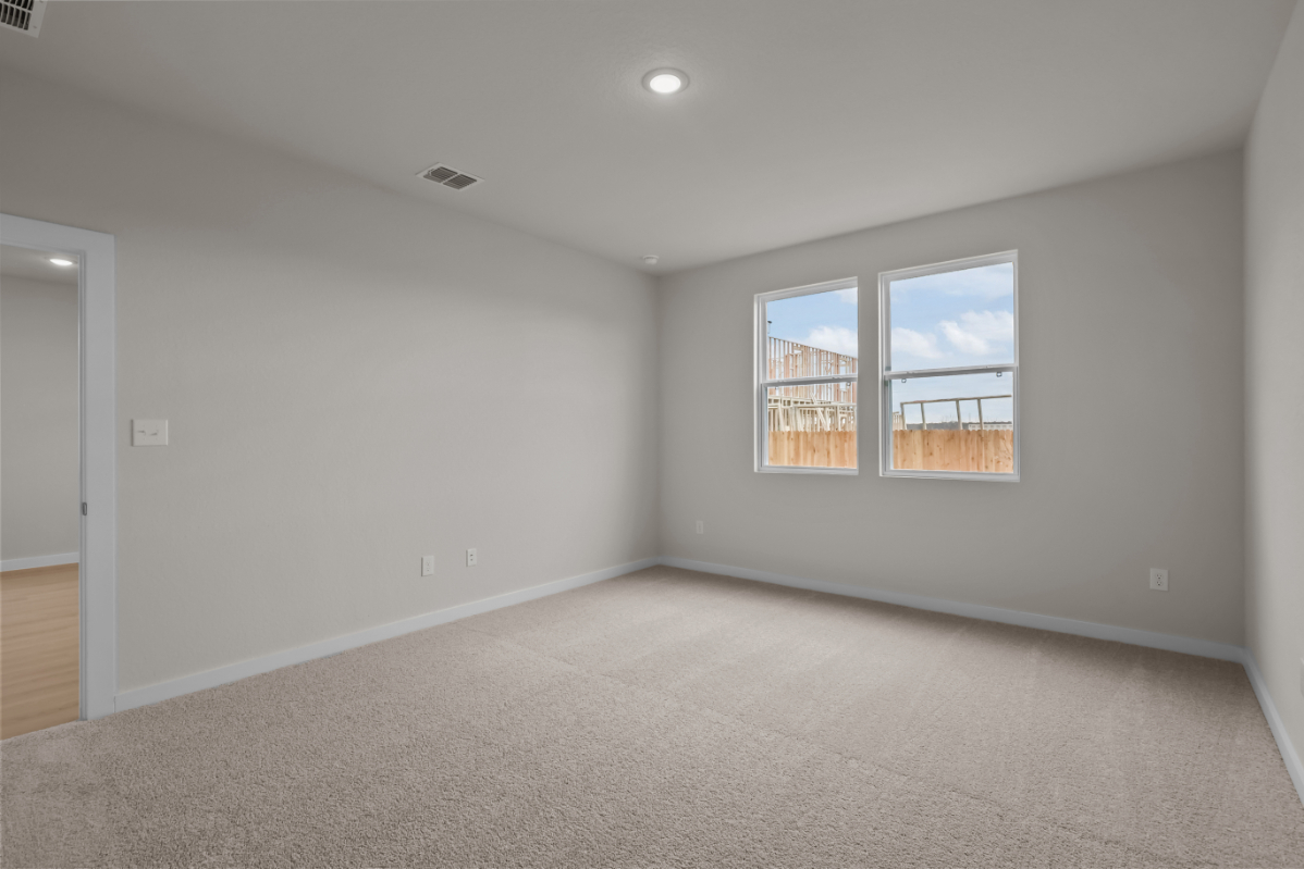 A room with a window and a carpet.