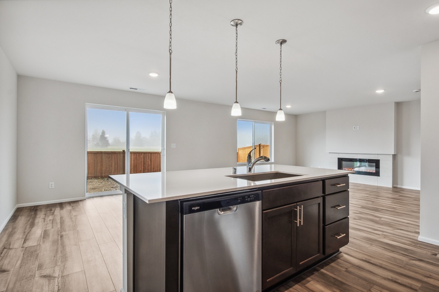 A kitchen with a sink and a refrigerator.