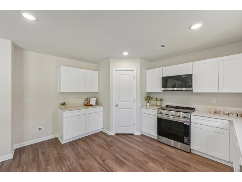 A kitchen with white cabinets.