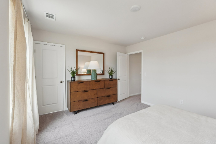 A bedroom with a bed and a dresser.