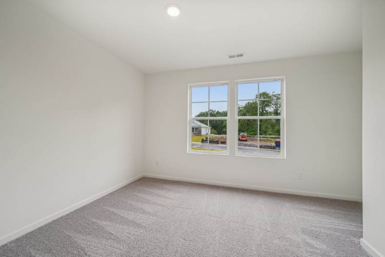 A room with a window and a carpet.