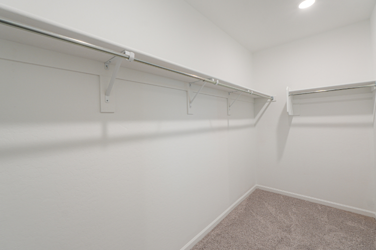 A white wall with a metal bar.