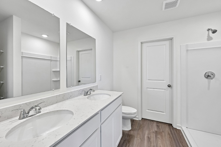 A bathroom with a toilet sink and mirror.