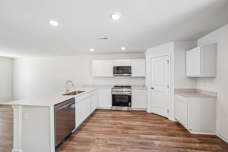 A kitchen with white cabinets.
