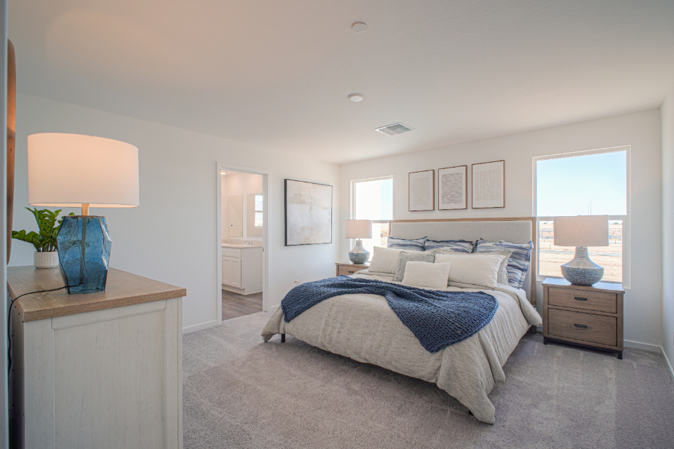 A bedroom with a bed and lamps.