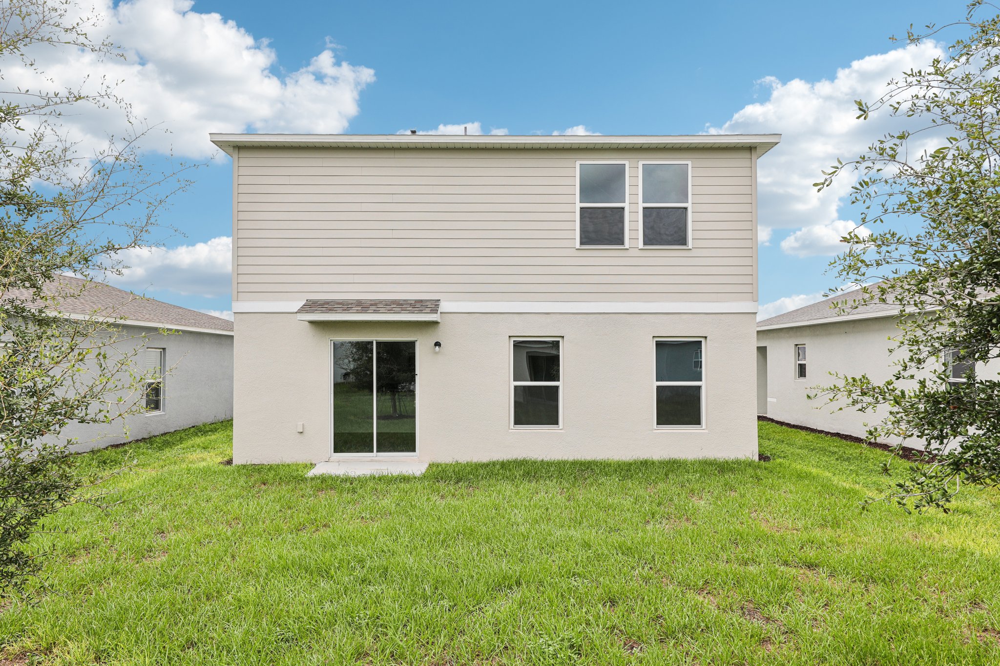 A white house with a green lawn.