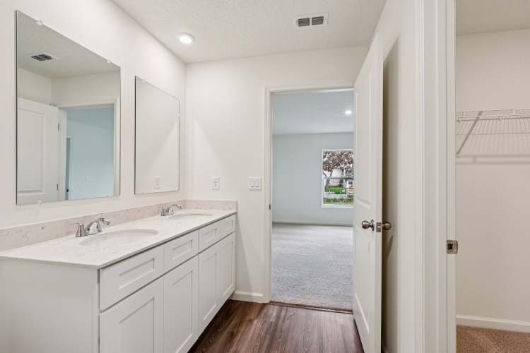 A bathroom with white cabinets.