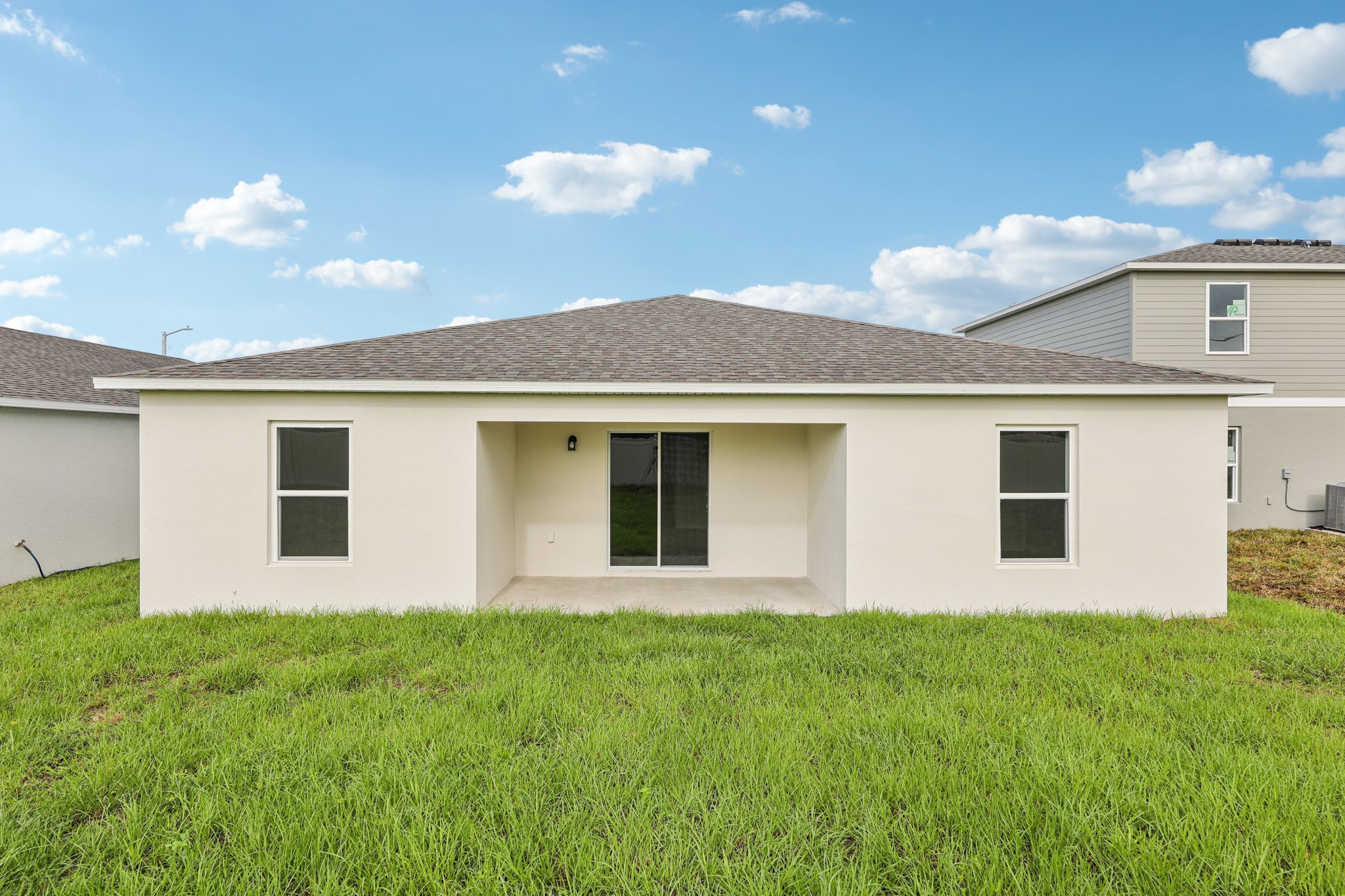 A white house with a green lawn.