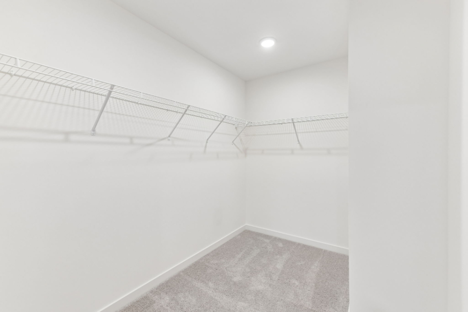 A white hallway with a metal railing.