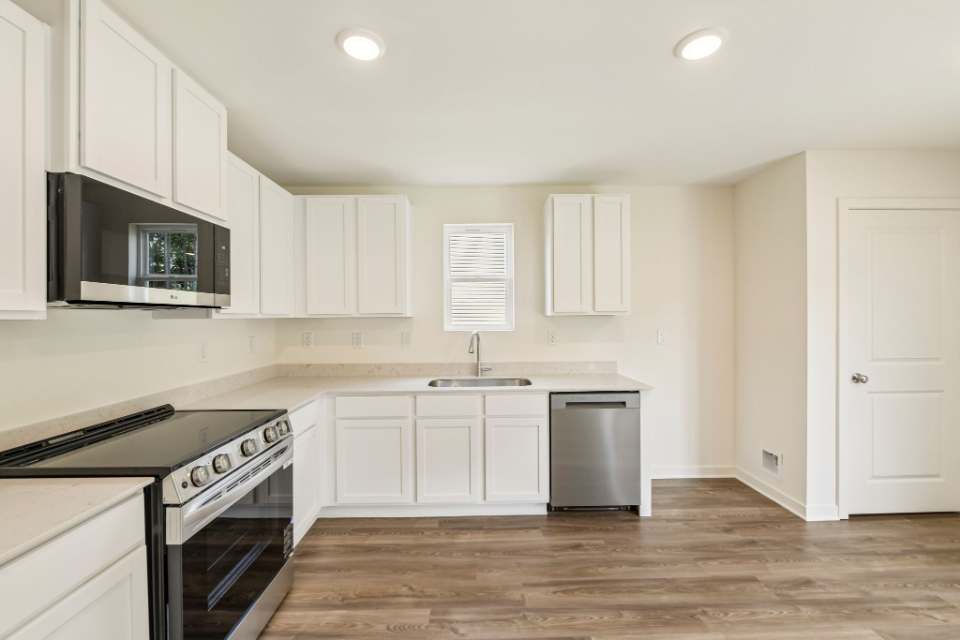 A kitchen with white cabinets.
