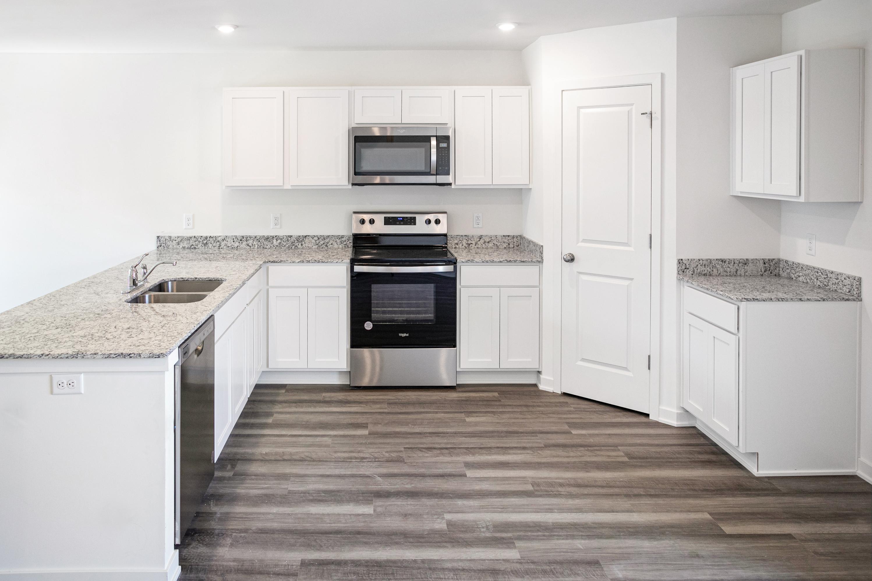 A kitchen with white cabinets.