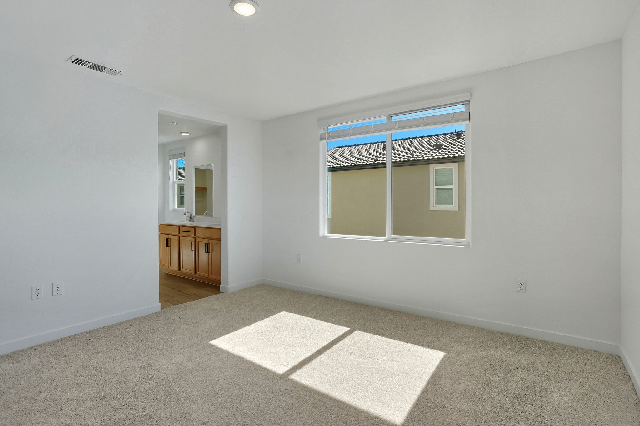 A room with a rug and a window.